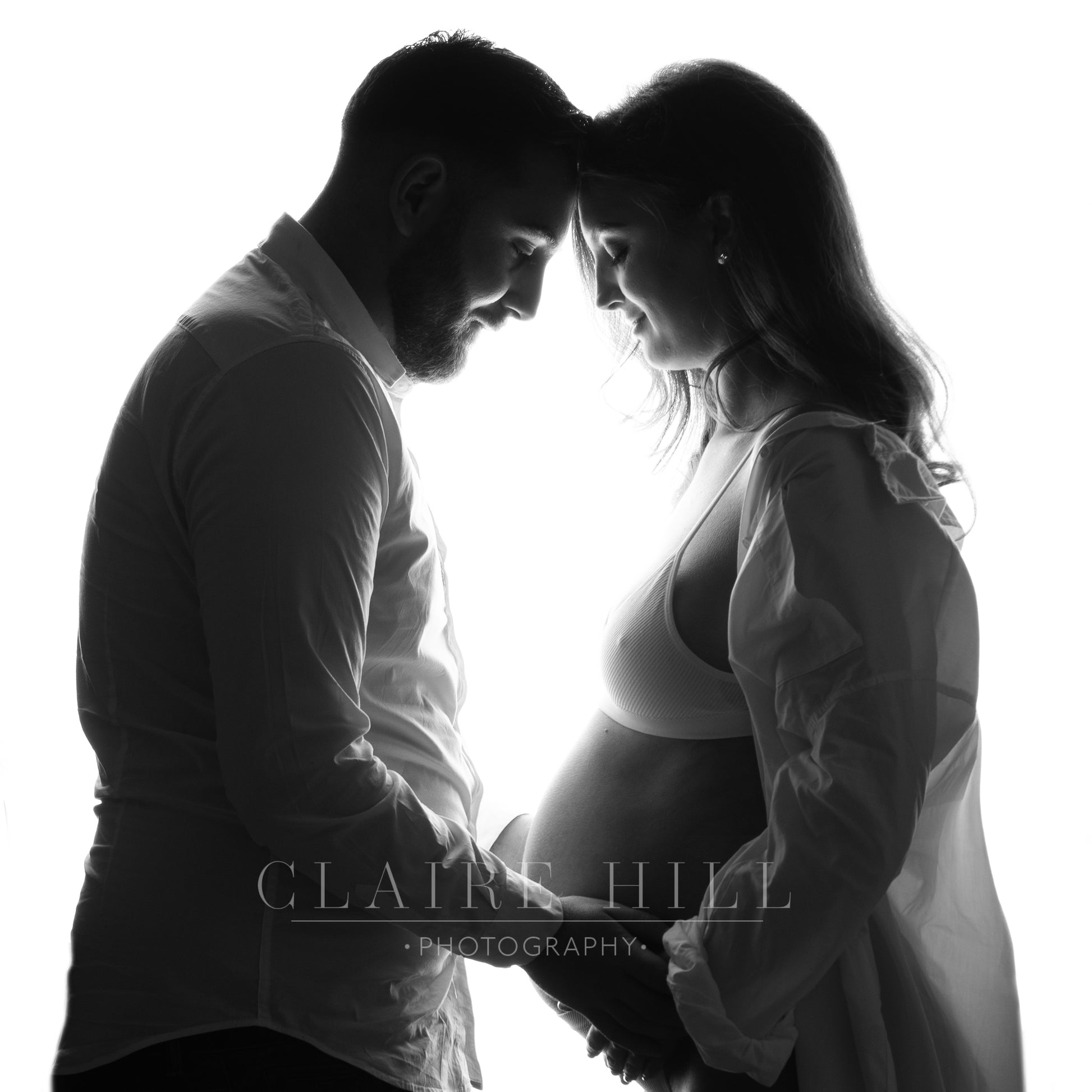 Professional back lit maternity photoshoot capturing the beauty of pregnancy, by Claire Hill Photography.